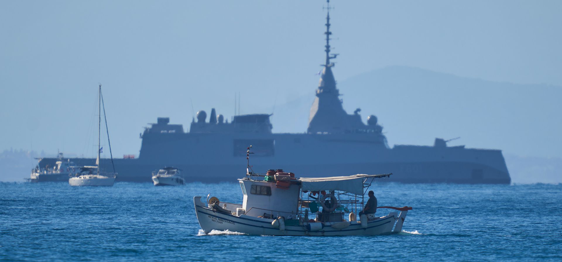 Un barco pesquero navega en el golfo Sarónico frente a la Kimon, la primera de cuatro fragatas modernas de fabricación francesa, como parte del importante programa de modernización militar de Grecia. Vista desde Alimos, cerca de Atenas, Grecia, el jueves 15 de enero de 2026. (Foto AP/Petros Giannakouris) Un barco pesquero navega en el golfo Sarónico frente a la Kimon, la primera de cuatro fragatas modernas de fabricación francesa, como parte del importante programa de modernización militar de Grecia. Vista desde Alimos, cerca de Atenas, Grecia, el jueves 15 de enero de 2026. (Foto AP/Petros Giannakouris)