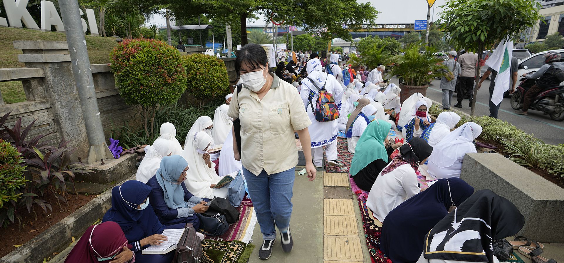 Una mujer camina mientras musulmanes leen el Corán durante la última semana del Ramadán en una calle peatonal en Bekasi, Java Occidental, Indonesia, el miércoles 27 de abril de 2022. Musulmanes de todo el mundo observan el sagrado mes de ayuno del Ramadán, donde se abstienen de comer , bebiendo y fumando desde el amanecer hasta el anochecer.