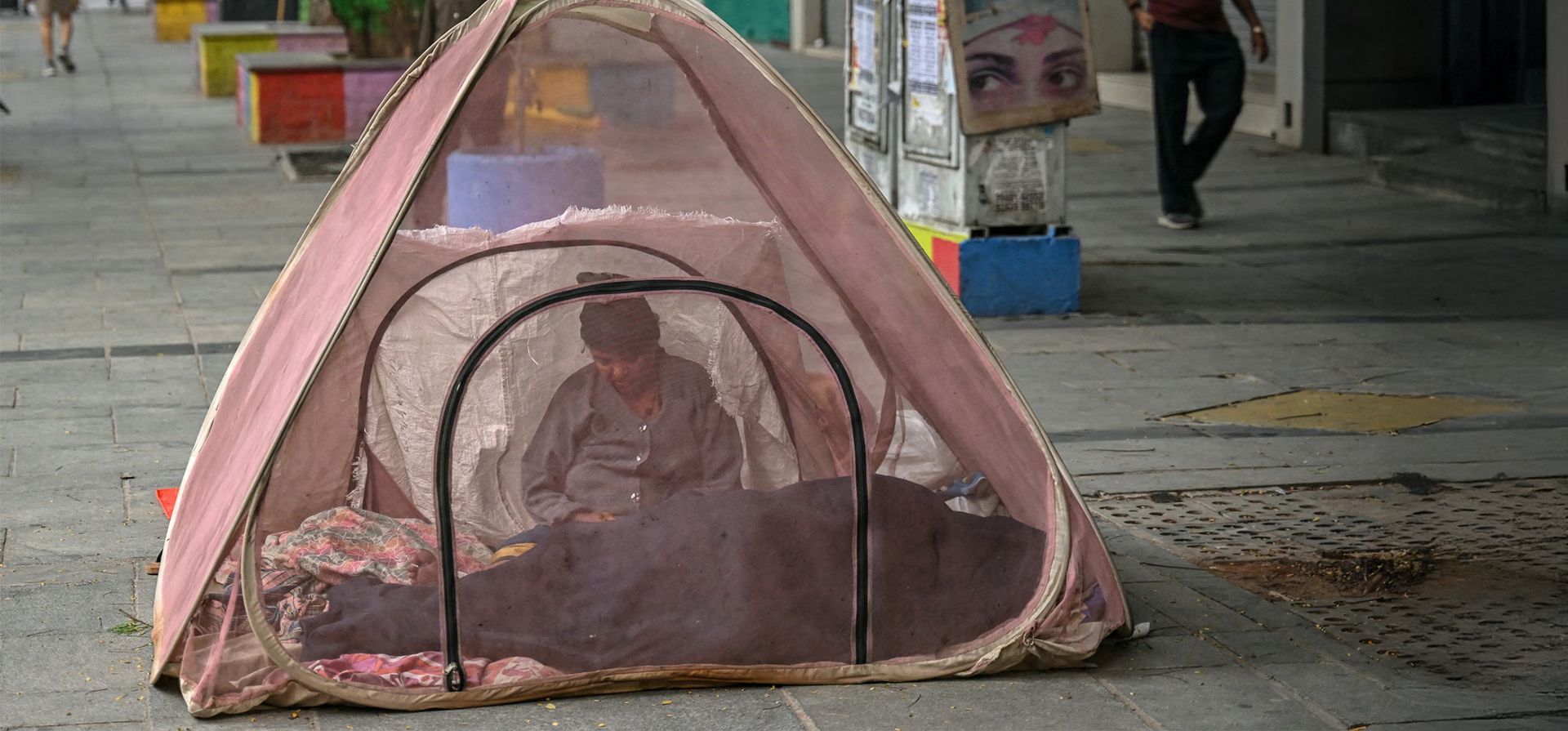 Una mujer sin hogar se sienta bajo una tienda antimosquitos en una mañana de invierno, Chennai, India. Fotografía: R Satish Babu/AFP/Getty Images Una mujer sin hogar se sienta bajo una tienda antimosquitos en una mañana de invierno, Chennai, India. Fotografía: R Satish Babu/AFP/Getty Images