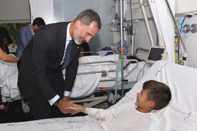 El rey Felipe saluda a uno de los niños que sufrieron heridas en el atentado.&nbsp;