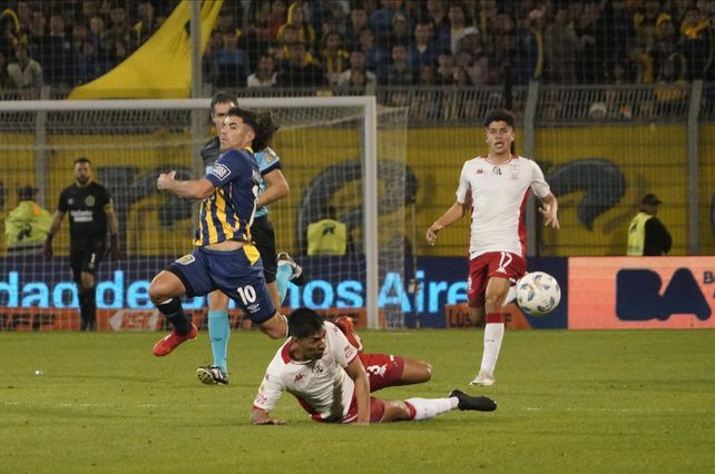 Malcorra intenta la personal frente al jugador de Huracán. Echavarría sigue la acción de cerca.