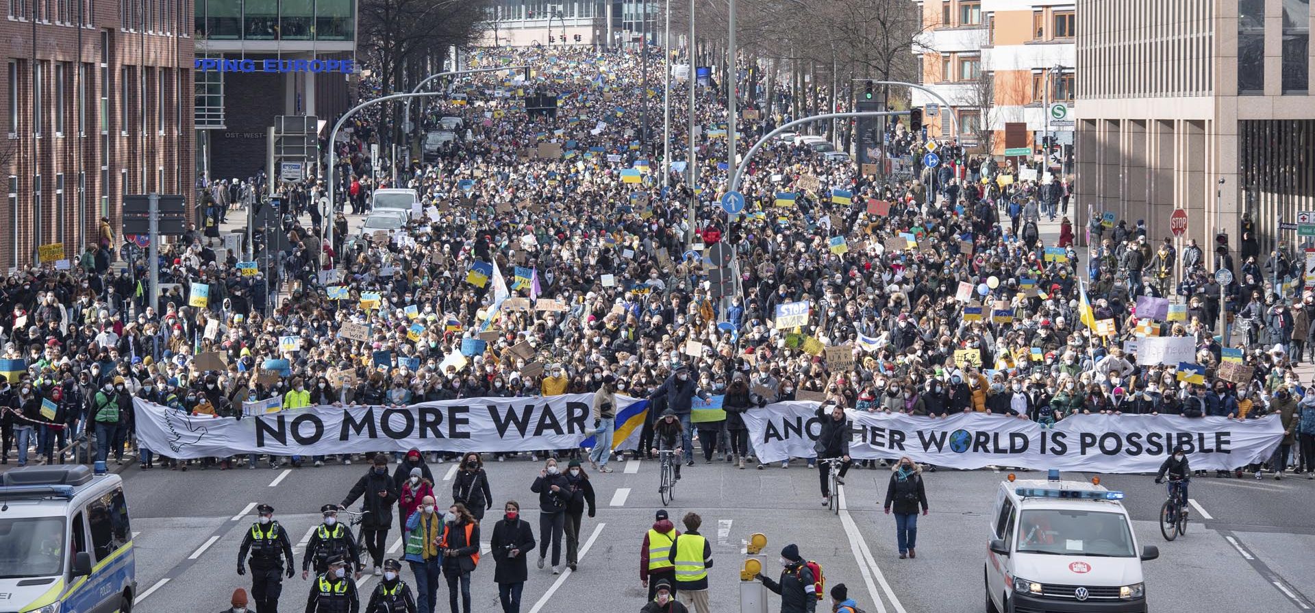 Miles de manifestantes caminan por Willy-Brandt-Strasse, una calle principal de Hamburgo, Alemania, con pancartas que dicen 