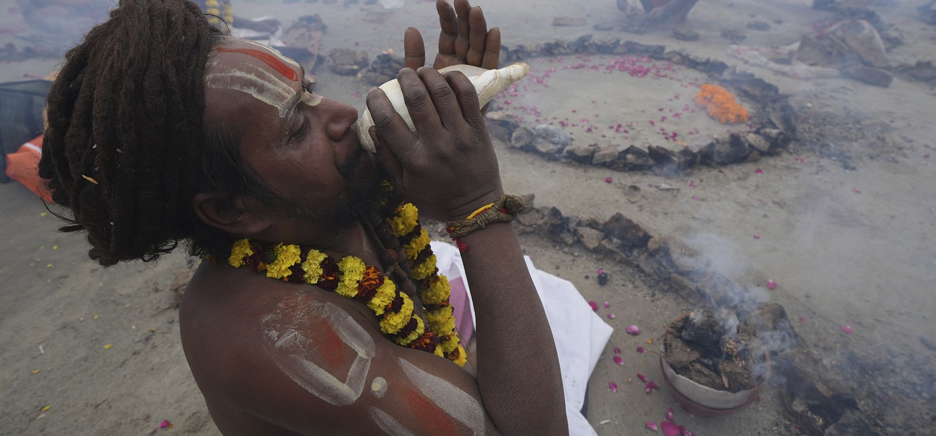 Un hombre santo hindú sopla una caracola mientras realiza un ritual en el Sangam, la confluencia de los ríos Ganges y Yamuna, el día de Basant Panchami en la feria tradicional anual de Magh Mela en Prayagraj, en el estado norteño indio de Uttar Pradesh, el jueves 26 de enero de 2023. (Foto AP/Rajesh Kumar Singh)