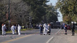 Homicidio en Funes. La policía y personal médico trabajan en el lugar donde se produjo el crimen, sobre ruta 9
