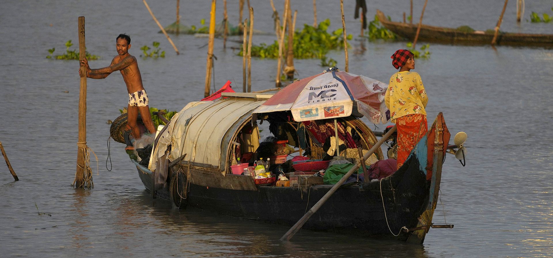 Pescadores mueven su bote de madera entre los ríos Mekong y Tonle Sap en Phnom Penh, Camboya, el martes 2 de agosto de 2022.