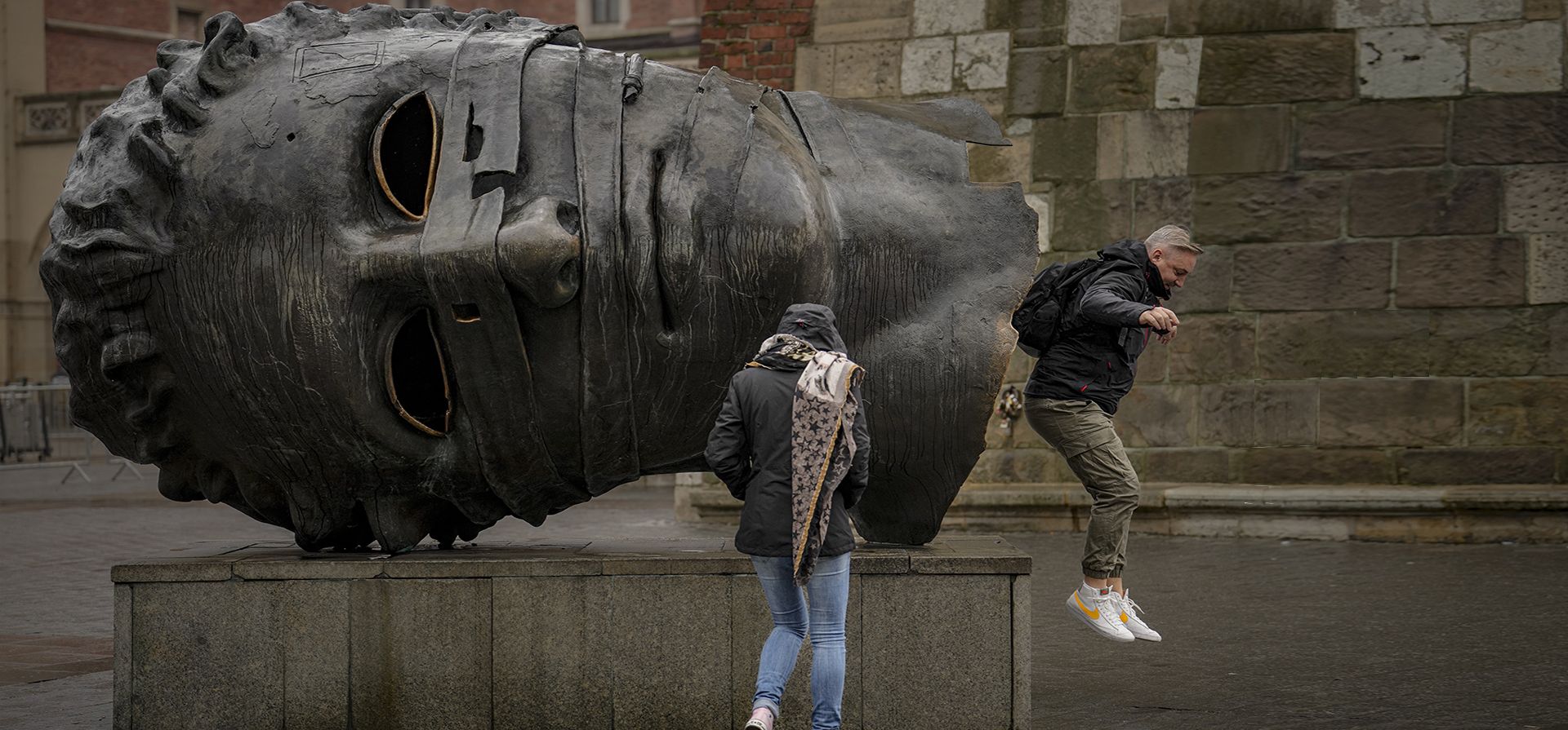 Un hombre salta desde el interior de una representación de Eros, el dios griego del amor, realizada por el escultor polaco Igor Mitoraj, en el centro de Cracovia, Polonia, el jueves 10 de noviembre de 2022. Eros Bound, una obra de arte que se dice que simboliza la decadencia de las civilizaciones se coloca en la plaza principal del siglo XIII del casco antiguo de Cracovia.