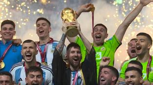 El capitán del equipo Lionel Messi y Emiliano “Dibu” Martínez (centro) junto al equipo y la Copa del Mundo en alto.