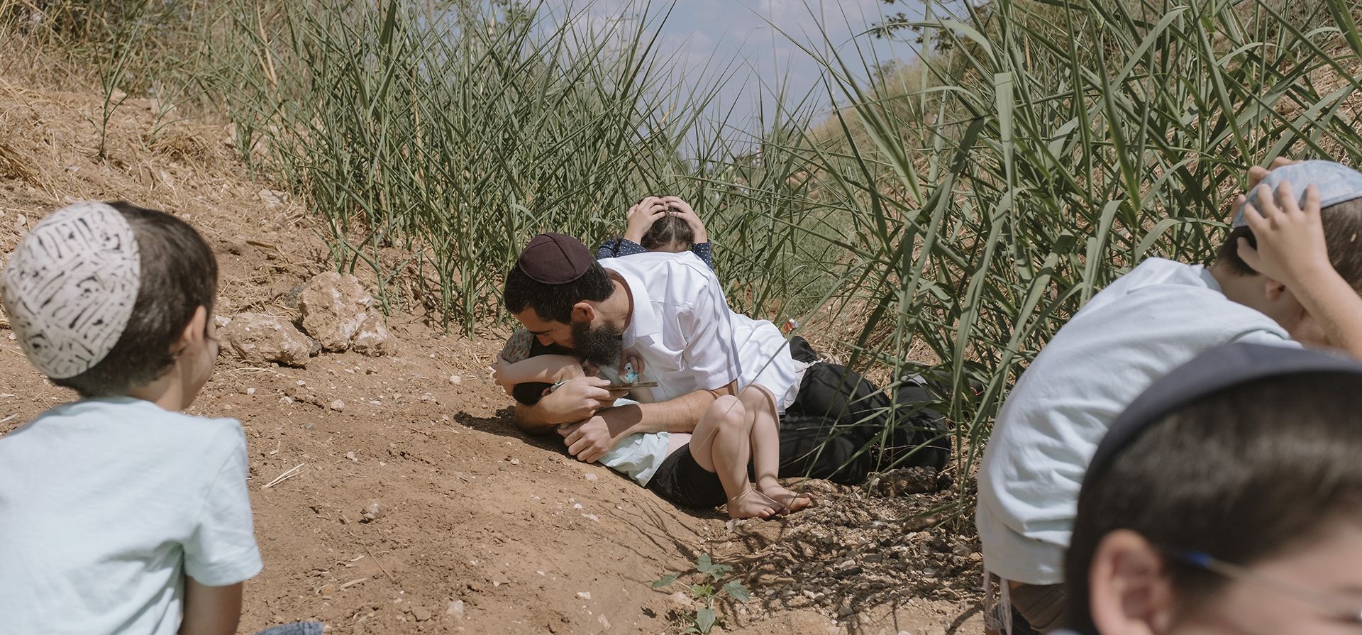 Los israelíes se ponen a cubierto mientras suena una sirena que advierte de la llegada de cohetes disparados desde la Franja de Gaza en Rehovot, Israel, el viernes 13 de octubre de 2023. (Foto AP/Dor Kedmi)
