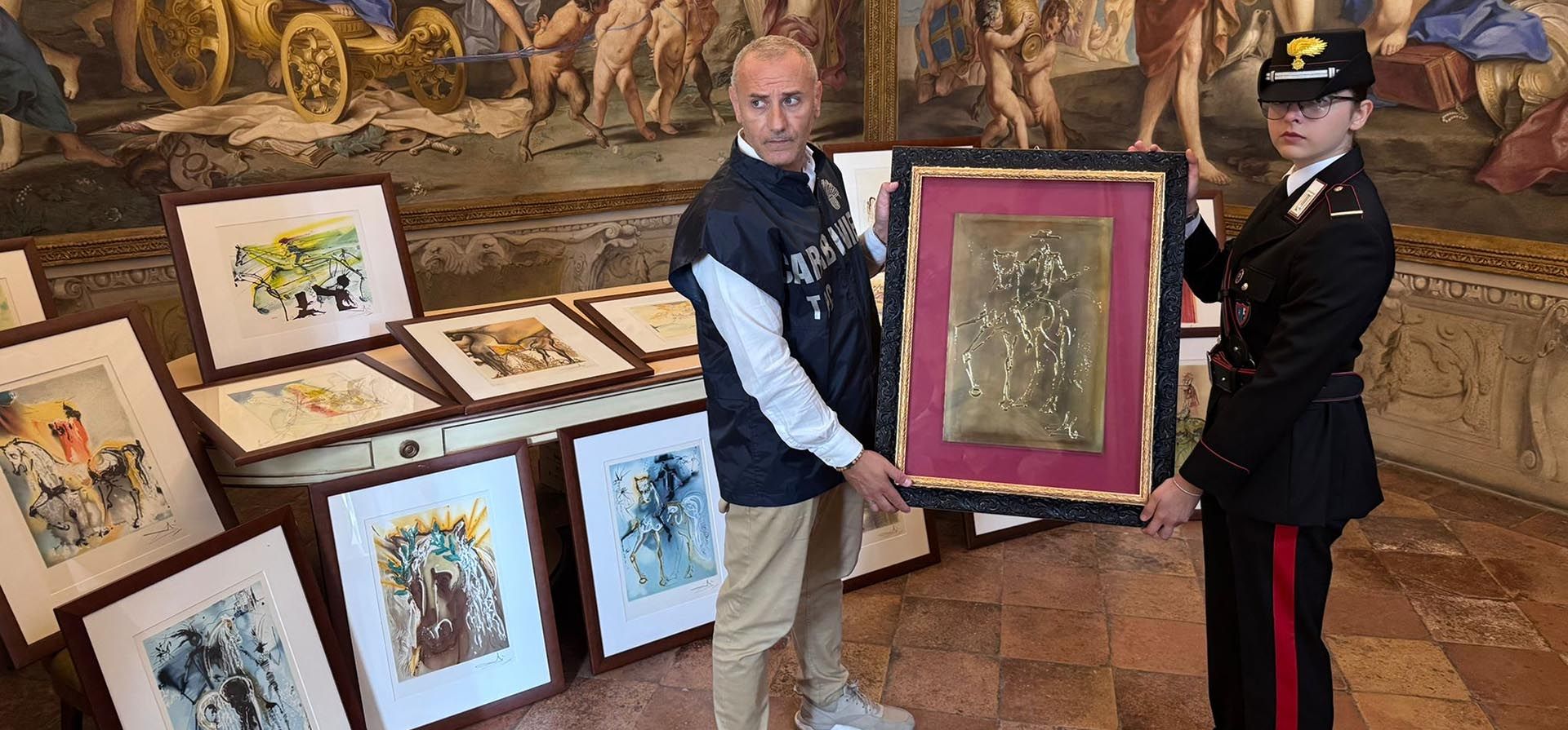 Dos oficiales carabineros posan con algunas de las 21 obras de arte de la exposición 
