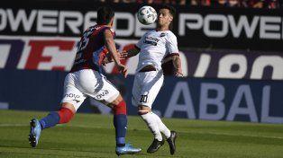 La tiene atada. Cristian Ferreira controla la pelota ante la marca de Gonzalo Luján. El armador estuvo inspirado.