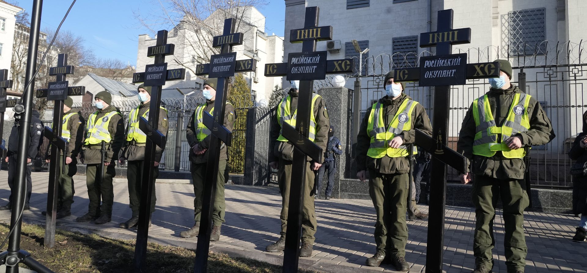 Policías se paran detrás de una instalación de cruces en las que está escrito "ocupante ruso" durante una manifestación contra Rusia frente a la embajada rusa en Kiev, Ucrania, el martes 22 de febrero de 2022. Rusia dice que su reconocimiento de la independencia para áreas en el este de Ucrania se extiende al territorio actualmente en manos de las fuerzas ucranianas.