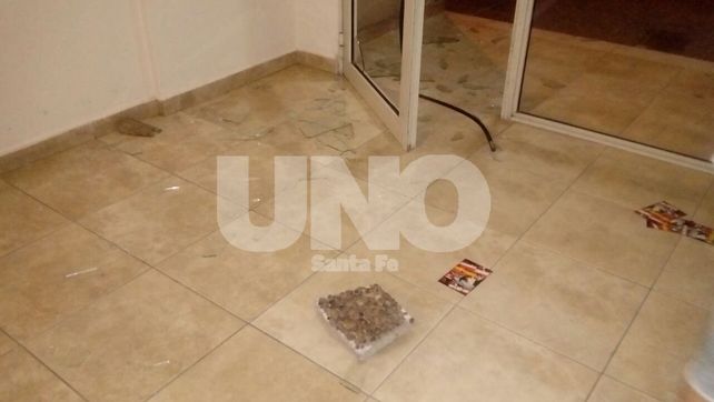 La baldosa con la que el delincuente rompió el vidrio de la puerta del edificio