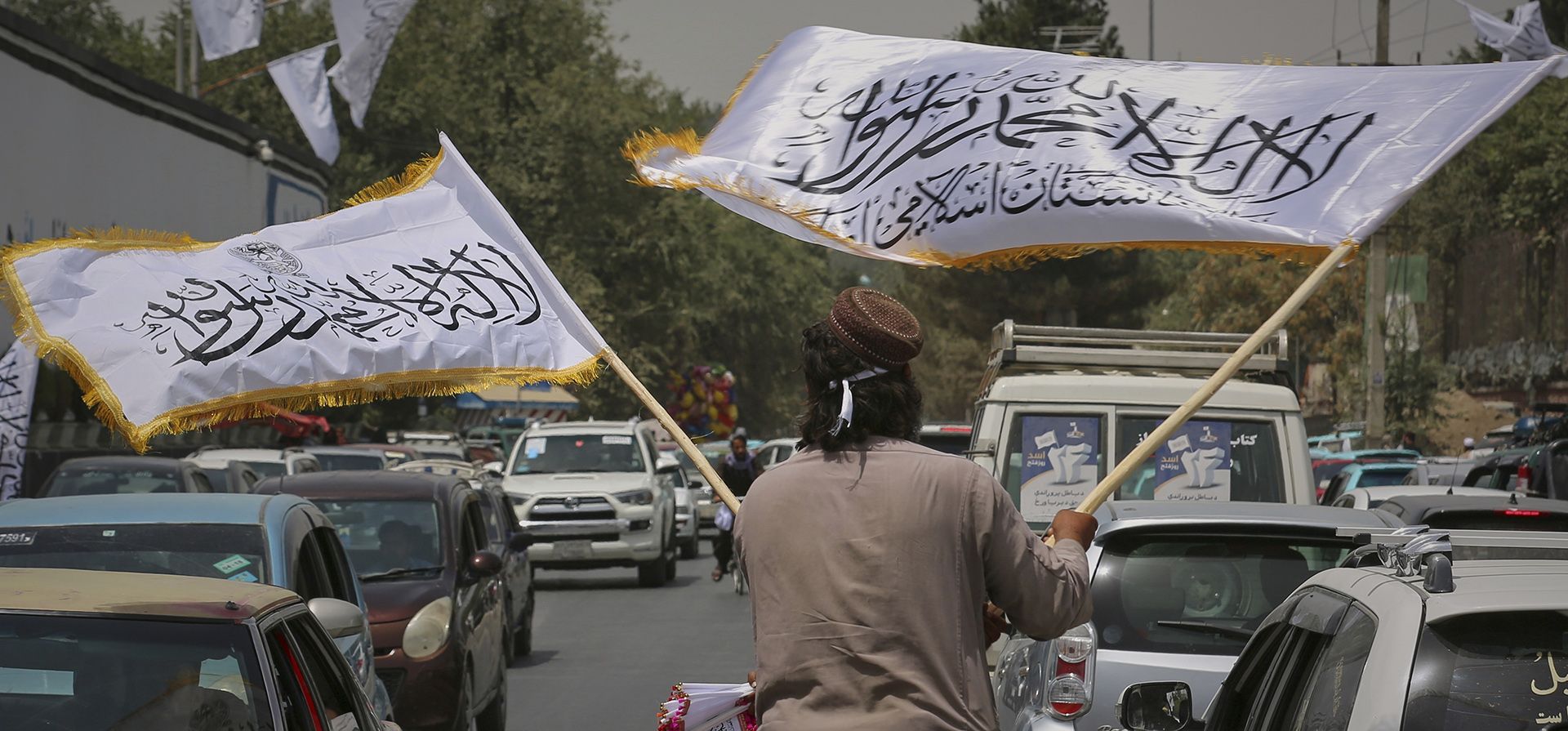 Un hombre ondea banderas talibanes a la venta en medio del tráfico antes de las celebraciones por el cuarto aniversario de la retirada estadounidense de Afganistán y el inicio del gobierno talibán en Kabul, Afganistán, el jueves 14 de agosto de 2025. (Foto AP/Siddiqullah Alizai) Un hombre ondea banderas talibanes a la venta en medio del tráfico antes de las celebraciones por el cuarto aniversario de la retirada estadounidense de Afganistán y el inicio del gobierno talibán en Kabul, Afganistán, el jueves 14 de agosto de 2025. (Foto AP/Siddiqullah Alizai)