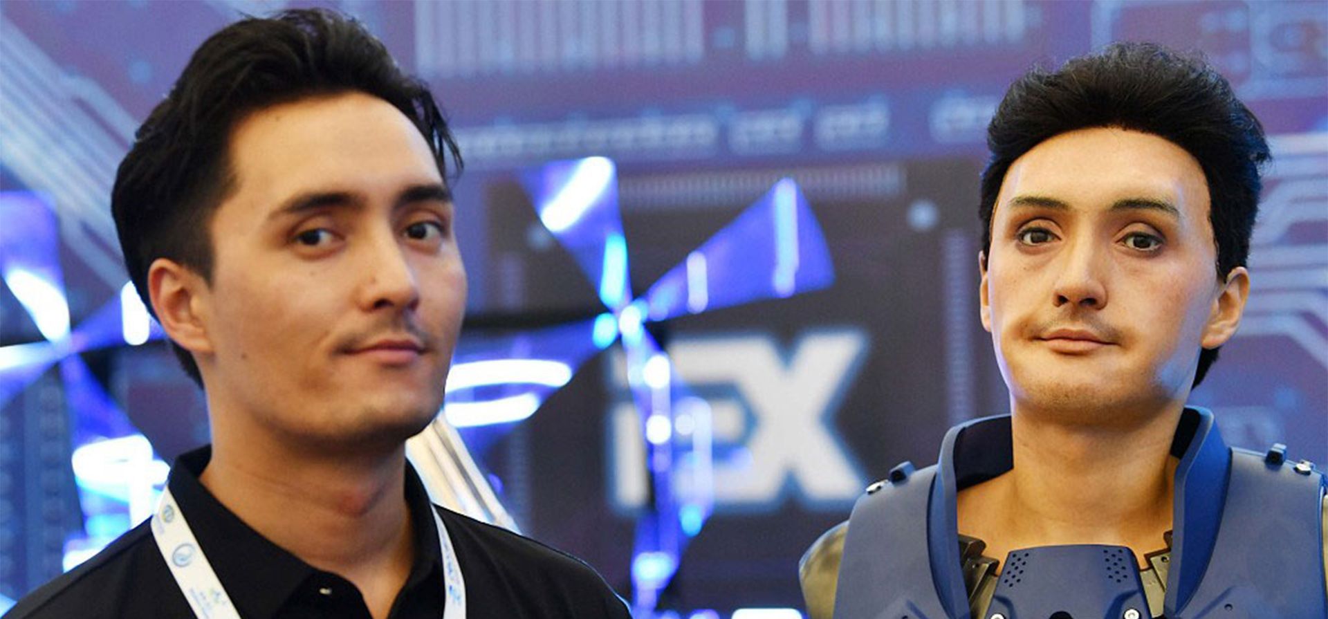 Un ingeniero de robots muestra un humanoide que se parece a él en la Conferencia Mundial de Robots, Beijing, China.