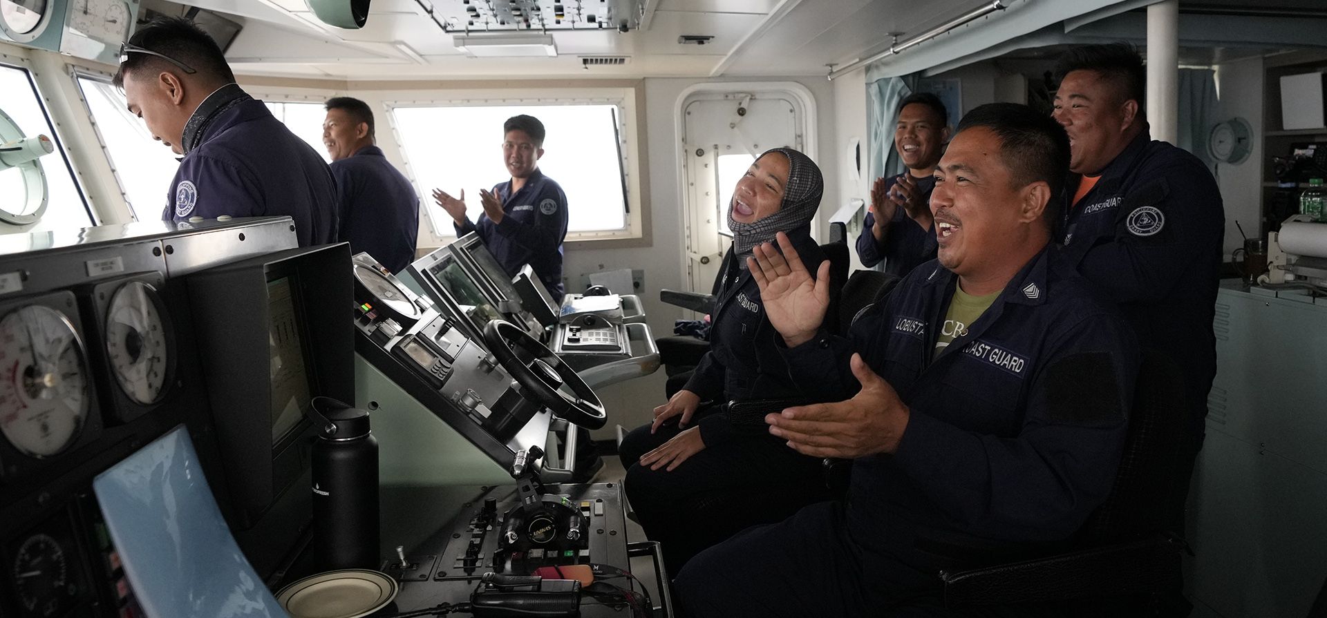 Los miembros de la Guardia Costera de Filipinas cantan una canción de cumpleaños a uno de sus camaradas en el puente de navegación del BRP Malabrigo durante una pausa en las actividades mientras patrullan y reabastecen a las tropas en las áreas ocupadas por Filipinas en el Mar de China Meridional. (Foto AP/Aaron Favila)