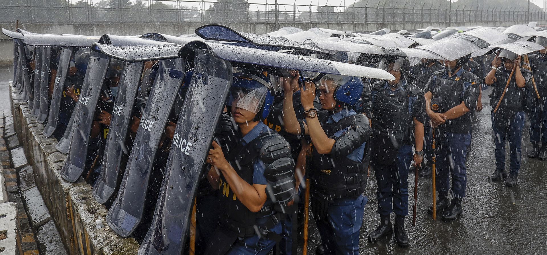 El personal de la policía usa escudos como cobertura durante la lluvia a lo largo de la carretera principal que conduce a la Cámara de Representantes antes del tercer discurso sobre el estado de la nación del presidente filipino Ferdinand Marcos Jr. en Quezon City, Filipinas, el lunes 22 de julio de 2024. (Foto AP /Marco Cristino) El personal de la policía usa escudos como cobertura durante la lluvia a lo largo de la carretera principal que conduce a la Cámara de Representantes antes del tercer discurso sobre el estado de la nación del presidente filipino Ferdinand Marcos Jr. en Quezon City, Filipinas, el lunes 22 de julio de 2024. (Foto AP /Marco Cristino)