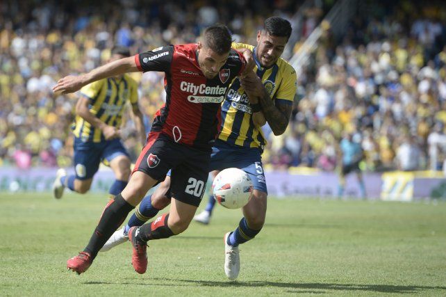 Julián Fernández y Emmanuel Ojeda luchan por la pelota en el último clásico rosarino.