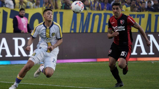 Alejo Veliz y Gustavo Velázquez luchan por el balón en el último clásico rosarino