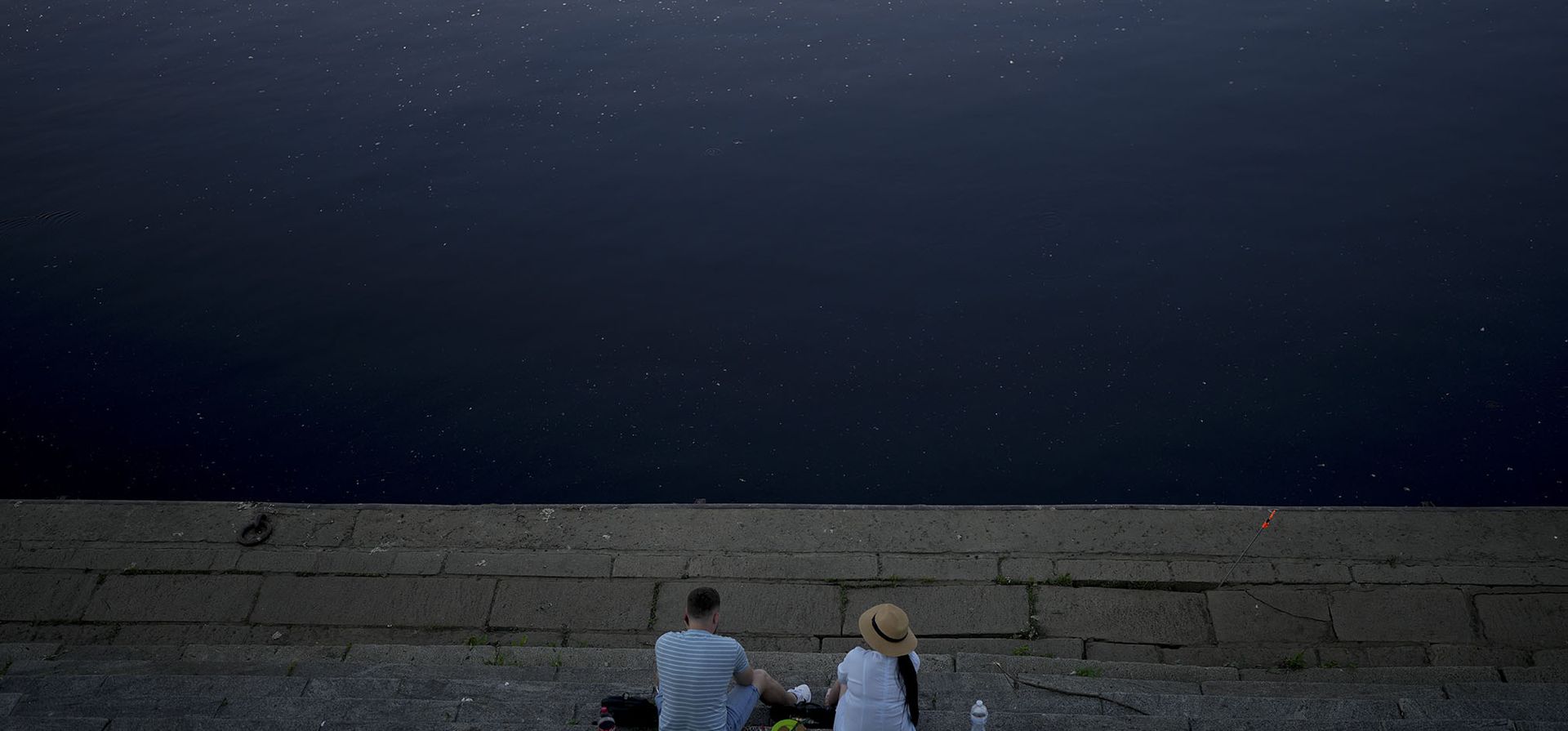 Una pareja descansa frente al río Dniéper en Kyiv. Con la guerra en los frentes del este y el sur, el verano de 2022 está resultando amargo para la capital de Ucrania.