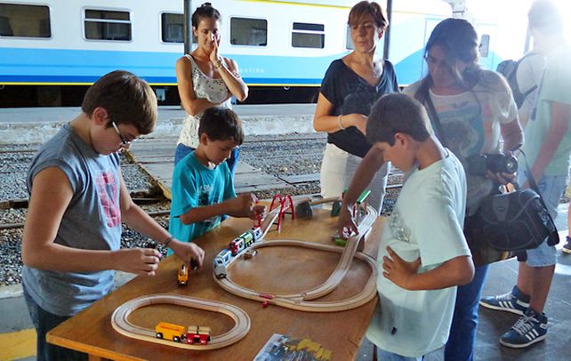 juegos e imágenes. Un grupo de chicos se divierte con trenes en escala.