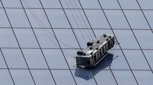 Un andamio con dos operarios, a punto de caer de una gran torre de Nueva York