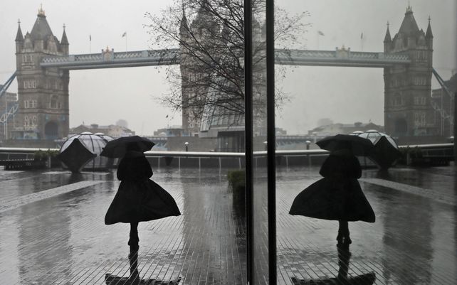 El reflejo de una mujer en una ventana desafiando el viento y la lluvia