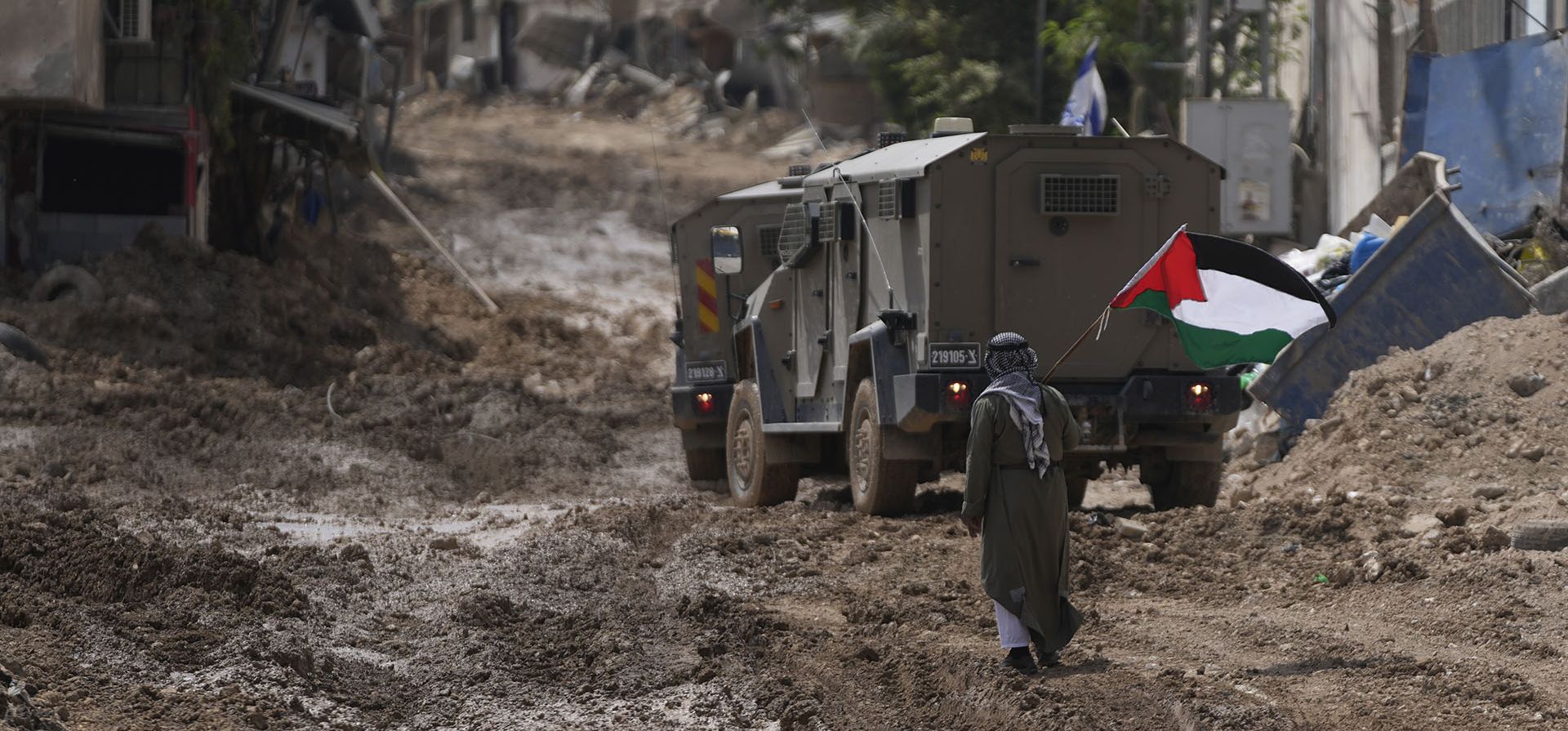 Un hombre ondea una bandera palestina mientras pasa junto a un vehículo blindado israelí durante una operación militar en el campo de refugiados de Tulkarem, en Cisjordania, el miércoles 4 de septiembre de 2024. (Foto AP/ Nasser Nasser) Un hombre ondea una bandera palestina mientras pasa junto a un vehículo blindado israelí durante una operación militar en el campo de refugiados de Tulkarem, en Cisjordania, el miércoles 4 de septiembre de 2024. (Foto AP/ Nasser Nasser)