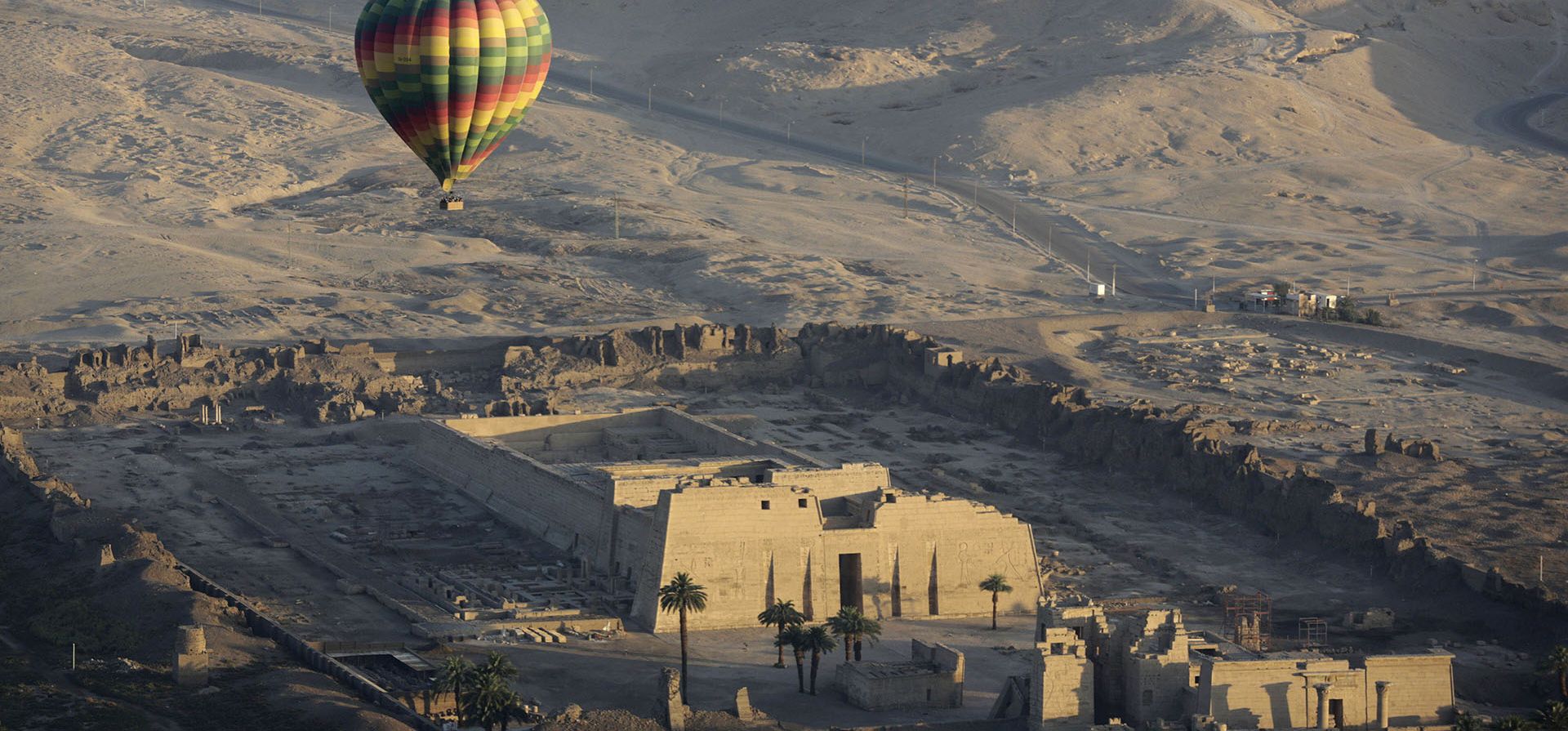 Un globo aerostático sobrevuela el templo mortuorio de Ramsis III en Medinet Habu, en la orilla occidental del río Nilo en Luxor, Egipto. Las autoridades egipcias suspendieron los vuelos en globo aerostático sobre la antigua ciudad, después de que dos turistas resultaron levemente heridos durante un viaje en la madrugada del lunes 18 de julio de 2022.