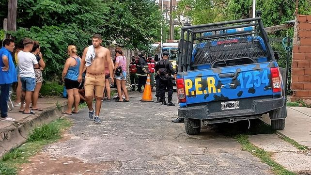 Policías y vecinos en cercanías de la vivienda donde se produjo el fatal incidente.&nbsp;
