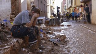 Una mujer descansa mientras residentes y voluntarios limpian una zona afectada por las inundaciones en Paiporta, cerca de Valencia, España, el viernes 1 de noviembre de 2024. (Foto AP/Alberto Saiz)