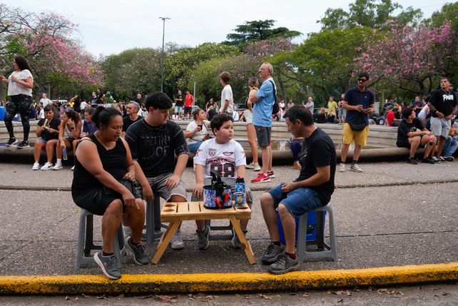Esperan sentados que lleguen los autos.