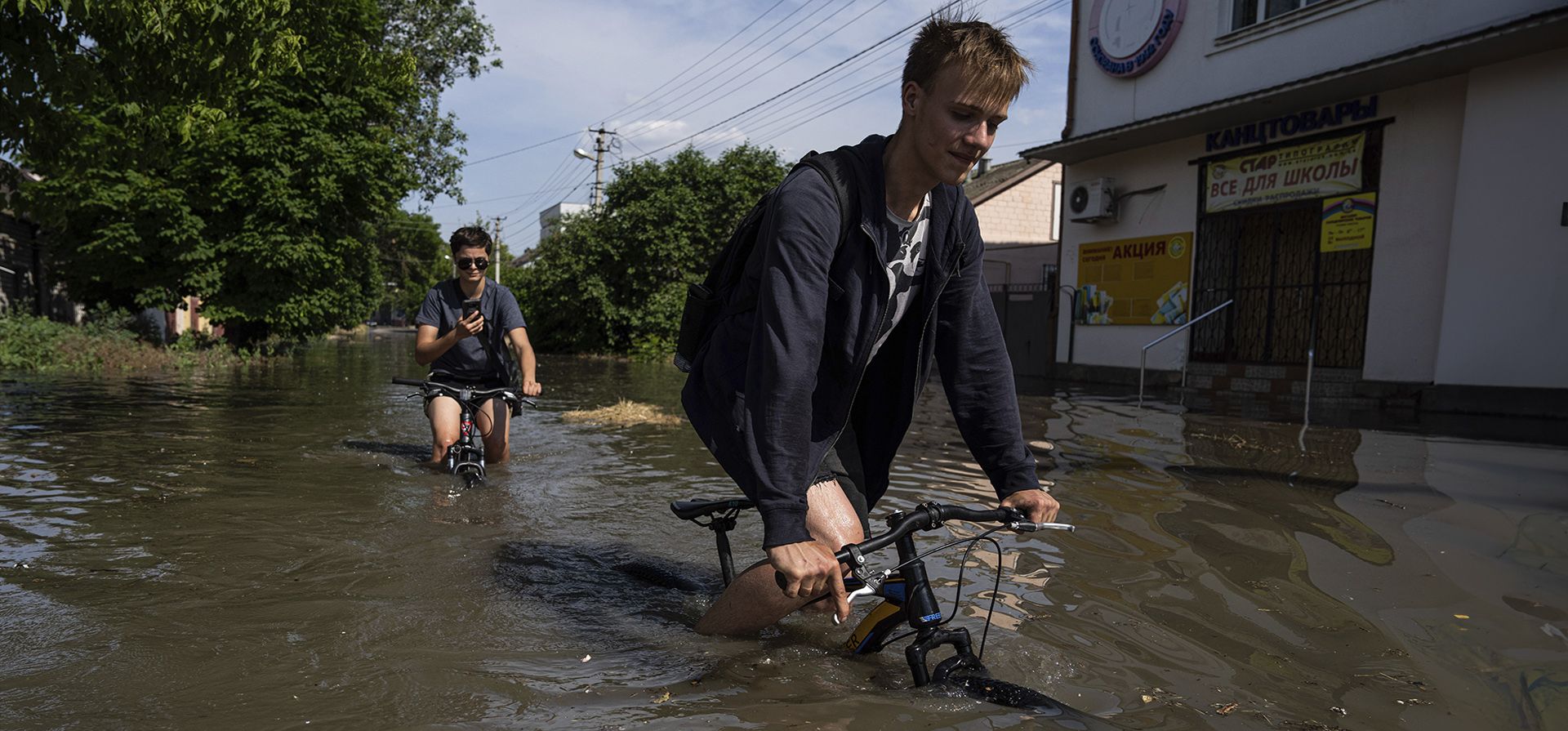 Los residentes locales intentan andar en bicicleta a lo largo de una carretera inundada después de que la represa Kakhovka explotara durante la noche, en Kherson, Ucrania, el martes 6 de junio de 2023. (Foto AP/Evgeniy Maloletka) Los residentes locales intentan andar en bicicleta a lo largo de una carretera inundada después de que la represa Kakhovka explotara durante la noche, en Kherson, Ucrania, el martes 6 de junio de 2023. (Foto AP/Evgeniy Maloletka)