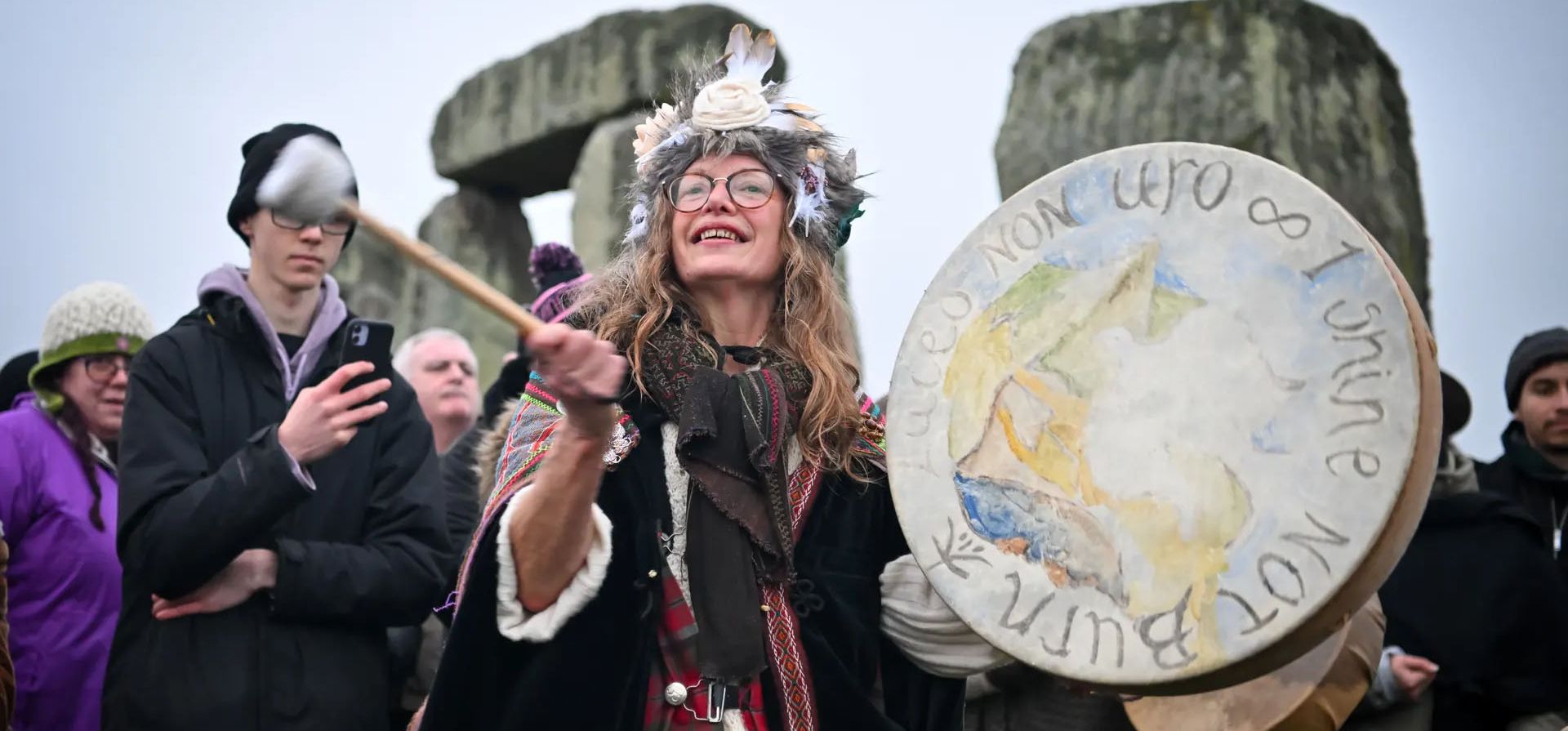 Amesbury, Inglaterra.Una mujer golpea un tambor mientras la gente saluda el amanecer más cercano al solsticio de invierno en Stonehenge. Fotografía: Finnbarr Webster/Getty Images
