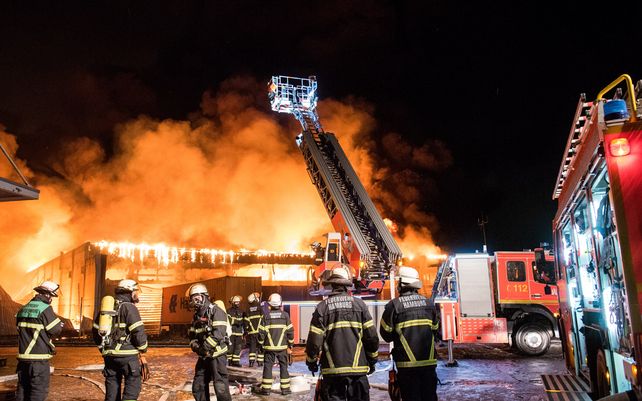 Bomberos trabajan para extinguir un incendio en un almacén en el distrito de Wilhelmsburg