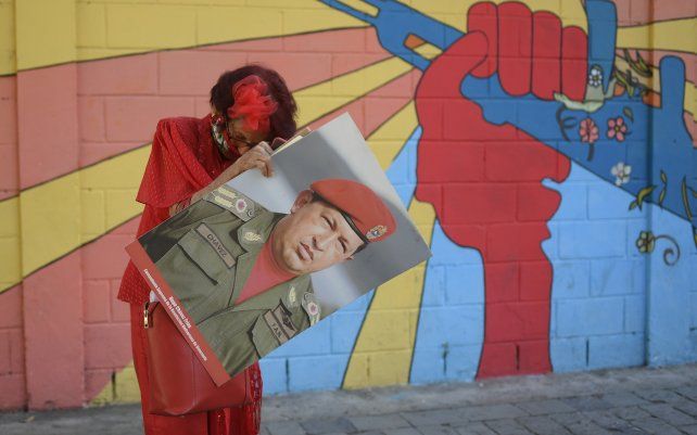 Una partidaria del gobierno conocida como "Caperucita Roja", sostiene una foto del fallecido presidente venezolano Hugo Chávez en Caracas.