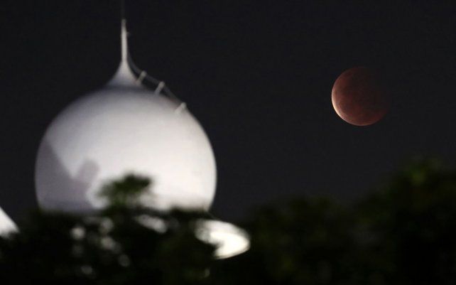 La luna llena se eleva sobre una mezquita mientras se estaba produciendo un eclipse lunar total en Yakarta, Indonesia. El primer eclipse lunar total en más de dos años coincidió con una superluna, creando un fenómeno llamado super "sangre" Luna.