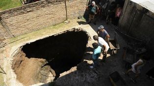 Una mujer cayó a un gran pozo que se abrió en el fondo de su casa
