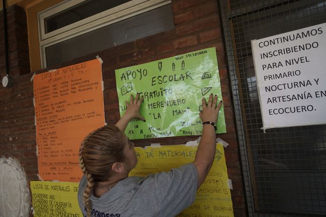 Rosy e Ivana colocaron un cartel en la escuela de Barra y Saavedra, para invitar a las familias a las clases de apoyo.
