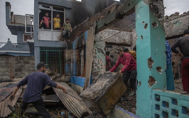 Aldeanos de Cachemira limpian una casa destruida en un tiroteo en Pulwama