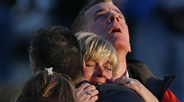 Sin consuelo. Una familia se abraza desesperada tras enterarse de que su hijo estaba entre las víctimas fatales del atentado.