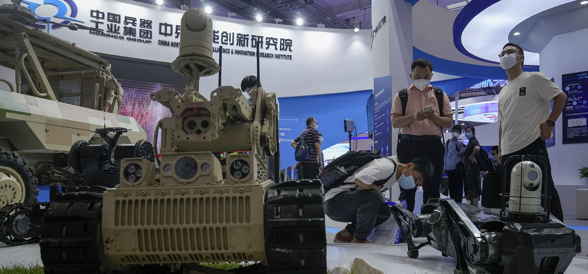 Los visitantes observan vehículos robóticos fabricados en China durante la Conferencia Mundial de Robots en el Centro Internacional de Conferencias y Exposiciones de Yichuang en Beijing.