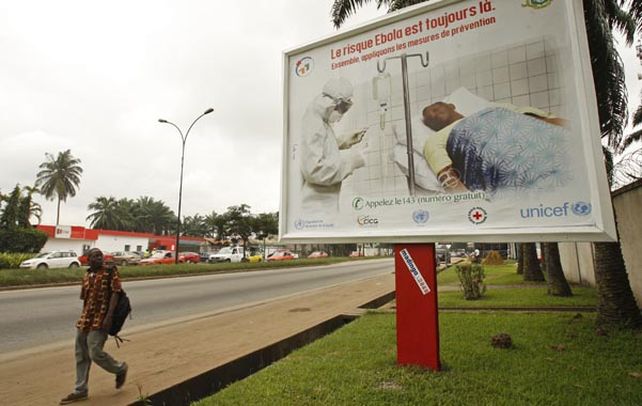 Prevención. Un habitante camina delante de un cartel de la campaña contra el ébola
