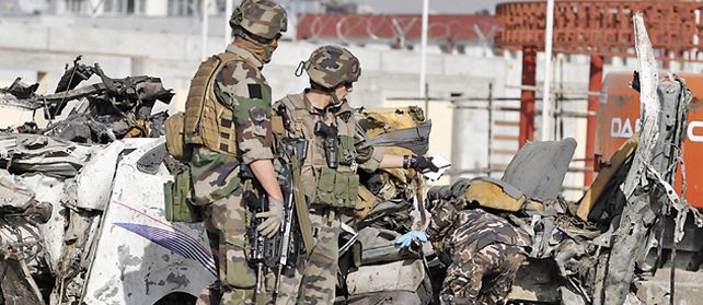 Soldados franceses inspeccionan los restos del vehículo que transportaba empleados sudafricanos de aviación en Kabul