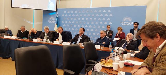 El funcionario Juan José Bahillo dialoga durante el encuentro flanqueado por los diputados Ricardo Buryaile (UCR) y Marcelo Casaretto (FdT).