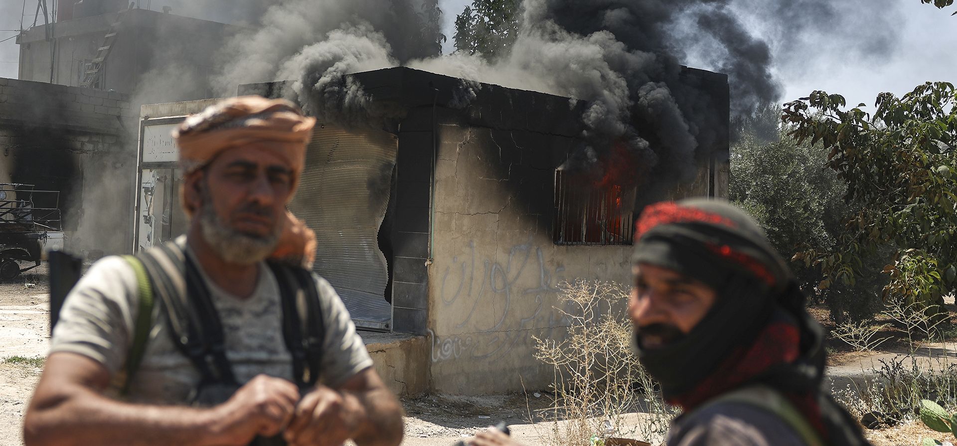 Combatientes beduinos se reúnen frente a una tienda incendiada en la aldea de Mazraa, a las afueras de la ciudad de Sweida, durante enfrentamientos entre clanes beduinos y milicias drusas, en el sur de Siria, el viernes 18 de julio de 2025. (Foto AP/Ghaith Alsayed) Combatientes beduinos se reúnen frente a una tienda incendiada en la aldea de Mazraa, a las afueras de la ciudad de Sweida, durante enfrentamientos entre clanes beduinos y milicias drusas, en el sur de Siria, el viernes 18 de julio de 2025. (Foto AP/Ghaith Alsayed)
