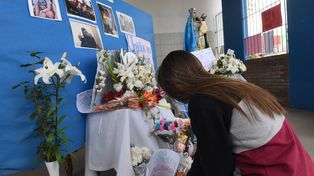 Una compañera de Ticiana le rinde su homenaje en el altar levantado en la puerta de la escuela a la que concurría.