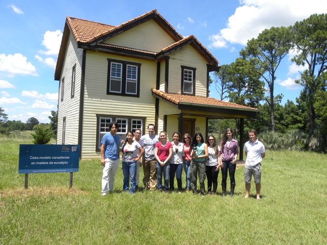 Estudiantes y tutores frente a la vivienda de madera en la Experimental del INTA Concordia.