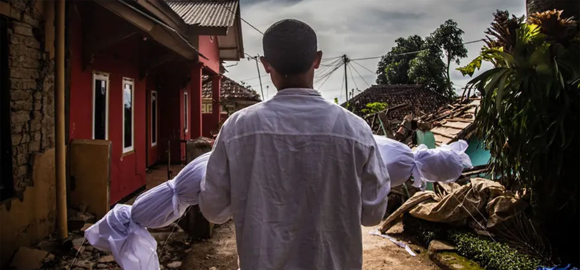 Un padre lleva a su hijo para ser enterrado después del terremoto de Cianjur, Indonesia. FOTO: Anditya Aji/AFP