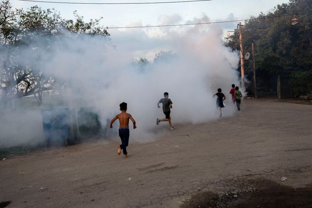 Chicos corren mientras se fumigaba en un barrio de Rosario esta semana.