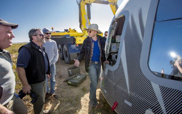 En esta foto sin fecha puesta a disposición por Blue Origin, Jeff Bezos, y otros inspeccionan Crew Capsule 2.0 después del aterrizaje en el oeste de Texas.